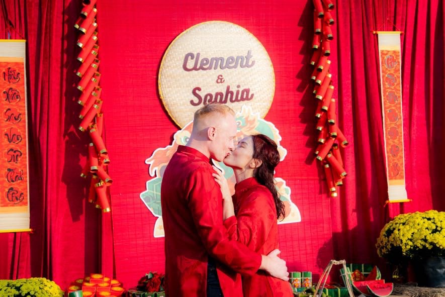 Clément & Sophia en áo dài rouge devant leur décor de fiançailles